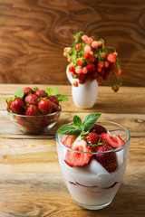 Strawberry with cream cheese on rustic wooden background