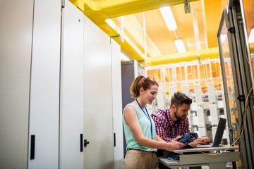 Technicians using laptop while analyzing server