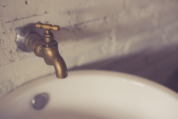 On the white wall the old brass faucet made with vintage filter.