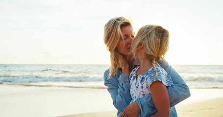 Mother and daughter having fun playing on the beach at sunset - Powered by Adobe