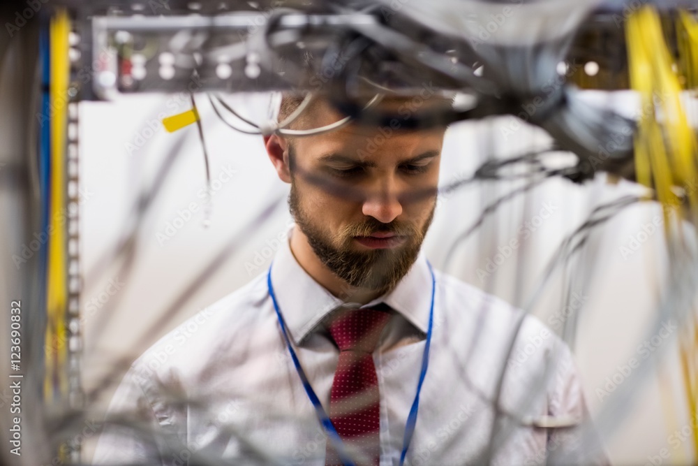 Poster technician checking cables in a rack mounted server