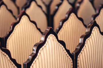 the ranks of the backs wooden and upholstered striped armchairs blurred art background