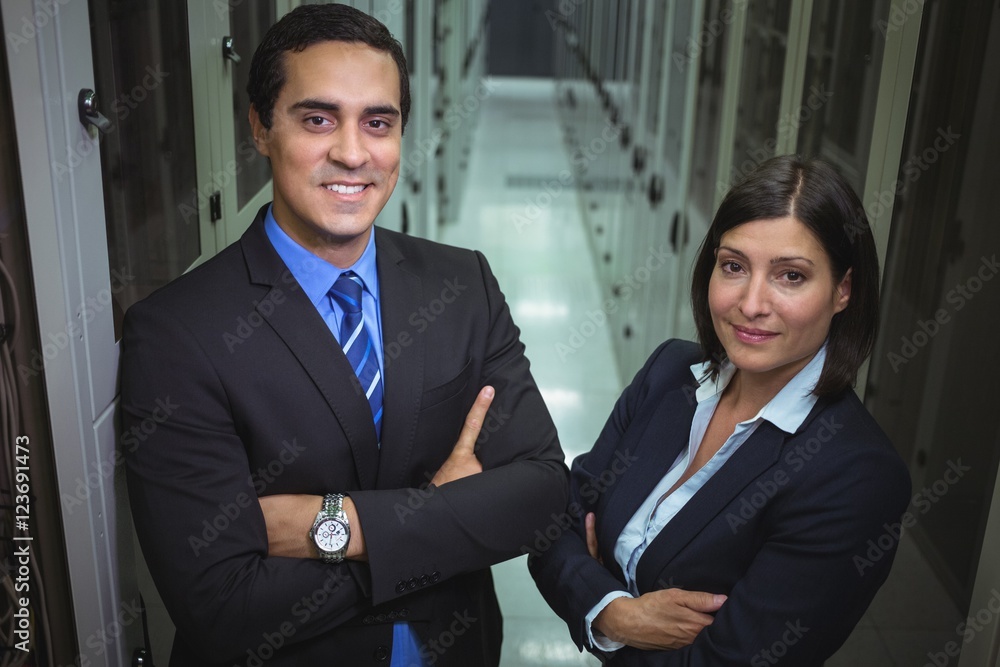 Poster technicians standing with arms crossed in a server room
