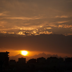 Naklejka premium Sunset at city of Hurghada with buildings and mountains silhouette