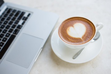 Laptop and coffee cup on wooden table