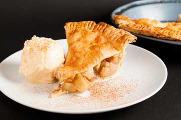 Homemade Organic Apple Pie on plate with cinnamon and ice cream.