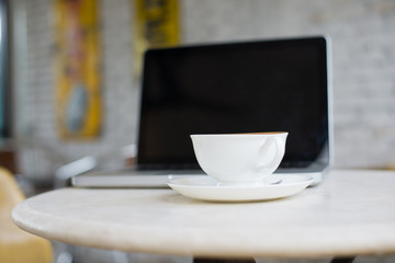 Laptop and coffee cup on wooden table