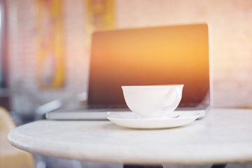 Laptop and coffee cup on wooden table