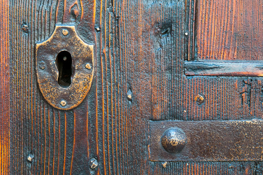 Closeup view of a metal keyhole of an old wooden door