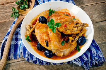 Stewed rabbit legs with olives and herbs.