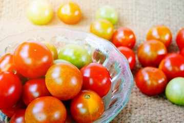 bowl of fresh tomatoes on sack background 