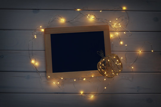 low key image of empty blackboard and christmas lights