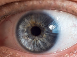 Blue man eye with contact lens, macro shot. Shallow depth of field.