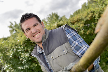 Man straining to pull a branch