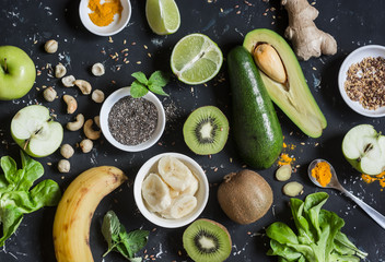 Green smoothie ingredients. Cooking healthy detox smoothies. On a dark background, top view