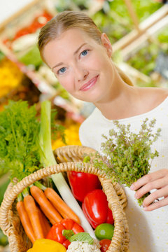 Lady adding herbs to purchases in a basket