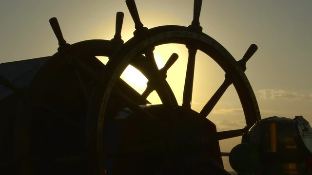 Steering wheel of the ship. Sunset.
