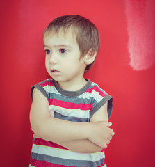 Cute little boy in front of red wall