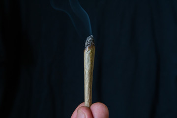 marijuana or cannabis joint smoking isolated against a black background
