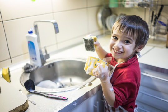A little cute boy washing dishes