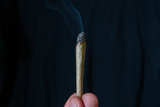 marijuana or cannabis joint smoking isolated against a black background
