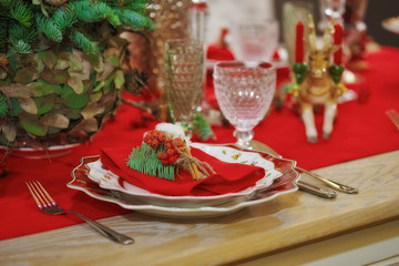 Served table in empty room decorated for Christmas. Thanksgiving table, decorated with fresh pine and candles.