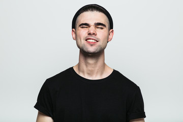 Obraz premium Studio portrait of adult man in hat feeling pain with his eyes closed on white background.