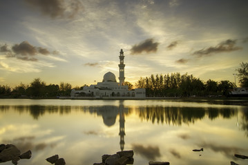 Fototapeta premium dark and soft image of beautiful mosque and reflection on the lake during sunset sunrise