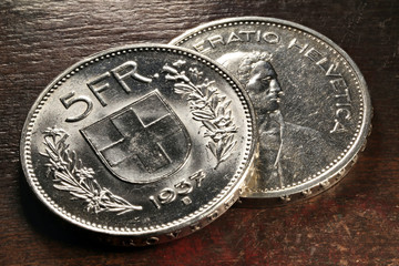 Schweizer 5 Franken Silbermünzen auf rustikalem Holztisch