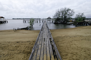 blurred image wooden fisherman jetty with cloudy sky. soft image water due to long exposure shot