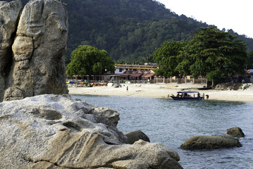 Fototapeta na wymiar tourist fiber boat anchored at the beach.rock and hill background