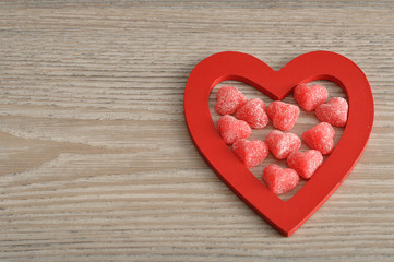 Naklejka na ściany i meble Valentine's Day. Wooden heart filled with sugar heart candy