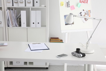 Office table with blank notepad and laptop, photo