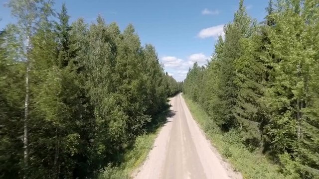 Drone video of a road in Sweden i a forest.