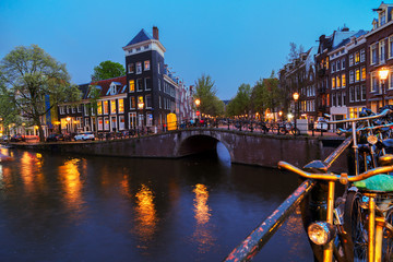 Fototapeta na wymiar Houses over canal with gloing lights at night, Amsterdam, Netherlands