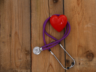 Heart with a stethoscope, isolated on wooden background