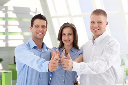 Successful startup business team giving thumbs up