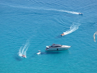Yacht con tender e moto d'acqua che si divertono in mezzo al mare
