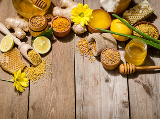 honeycombs ,honey, ginger, pollen, lemon on a wooden table
