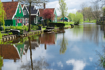 Fototapeta na wymiar rural dutch scenery of small traditional town Zaanse Schan with reflections in canal, Netherlands