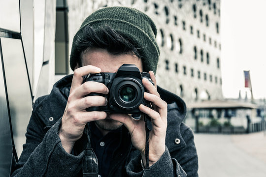 Ritratto di un uomo giovane e caucasico, mentre scatta una foto con la sua macchina fotografica, in vacanza.