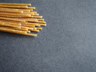 Wholegrain pasta on black background