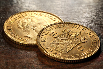 Dutch Wilhelmina gold coins on rustic wooden background