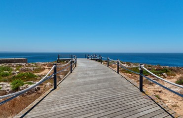 Wooden pier in the ocean with blue sky