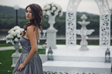 The adorable bridesmaid stands near archway