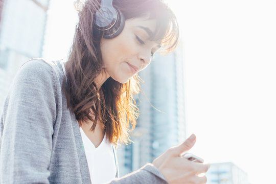 Young Woman Listening Music with Headphones and Mobile Phone  . New York City US