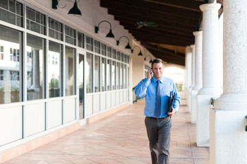 Businessman with mobile phone outside office