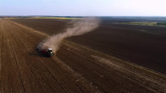 Cultivation soil: farm tractor plowing on cropped field after harvesting HD video aerial top view. Agricultural machine equipment. Preparation for sowing seed