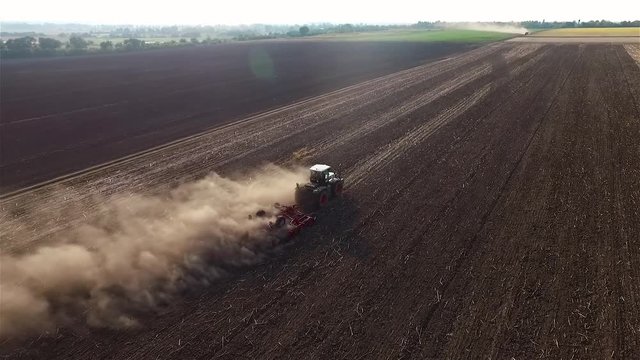 Cultivation soil: farm tractor plowing on cropped field after harvesting HD aerial video. Agricultural machine equipment. Preparation for sowing seed