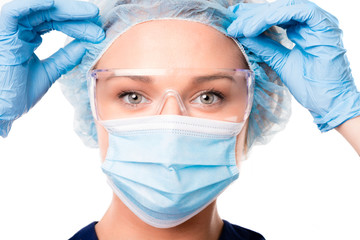 Female doctor nurse practitioner surgery hospital worker in hair cap face mask and safety eye glasses isolated on white background